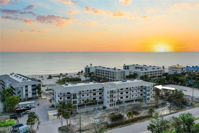 aerial view at dusk featuring a water view