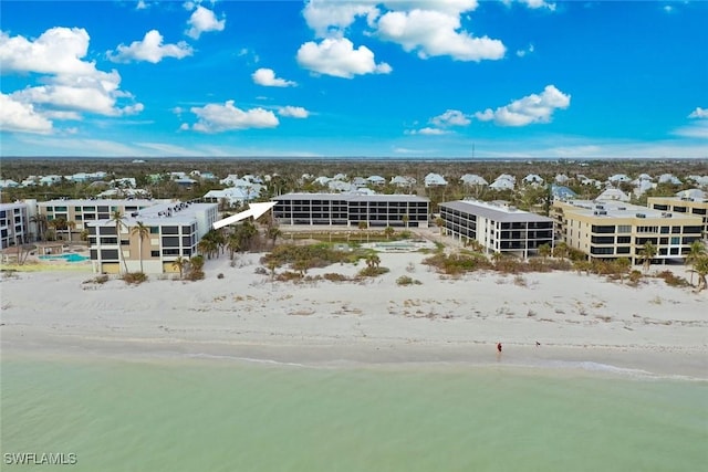 birds eye view of property with a water view and a beach view