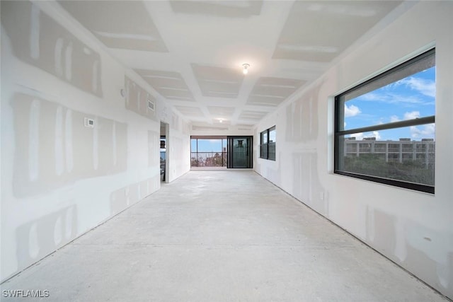 hallway with a wealth of natural light and concrete floors