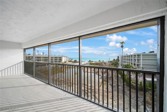 unfurnished sunroom featuring a water view