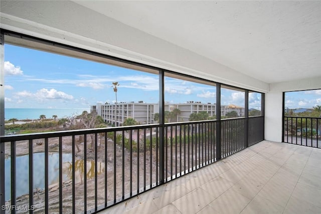 unfurnished sunroom featuring a water view