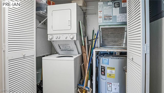 laundry room with electric water heater and stacked washer / dryer