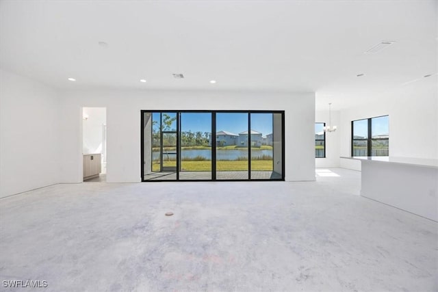 spare room featuring a water view, a wealth of natural light, and a chandelier