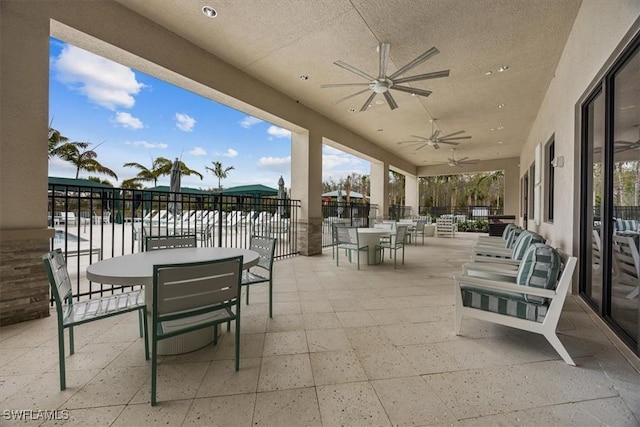 view of patio with a water view and ceiling fan