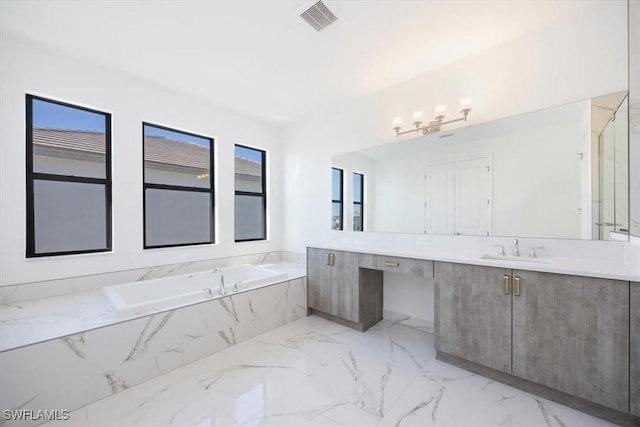 bathroom with vanity and tiled tub