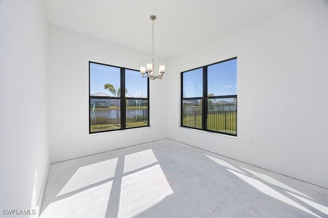 spare room featuring a chandelier and a water view