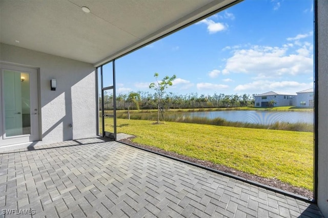 unfurnished sunroom featuring a water view