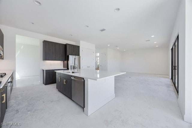 kitchen featuring appliances with stainless steel finishes, sink, and a kitchen island with sink