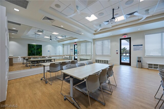 dining area featuring a tray ceiling and light hardwood / wood-style flooring