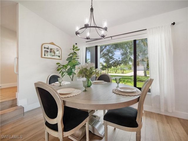 dining room with light wood-type flooring and an inviting chandelier