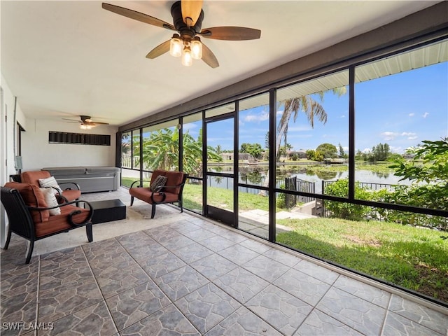 unfurnished sunroom with a water view, ceiling fan, and a healthy amount of sunlight