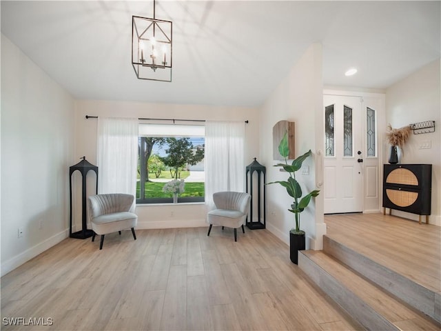 sitting room with light hardwood / wood-style floors and a chandelier