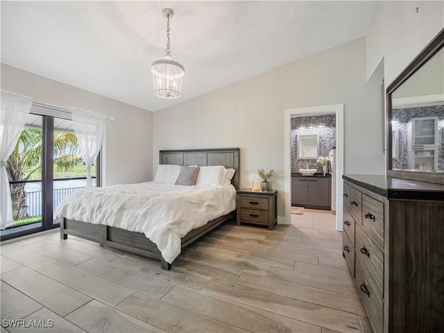 bedroom with access to exterior, vaulted ceiling, and a notable chandelier