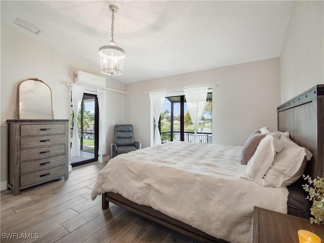 bedroom featuring hardwood / wood-style flooring, access to exterior, a wall mounted AC, and multiple windows