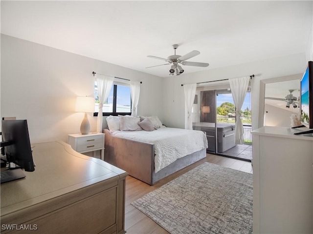 bedroom featuring access to outside, multiple windows, ceiling fan, and light hardwood / wood-style floors