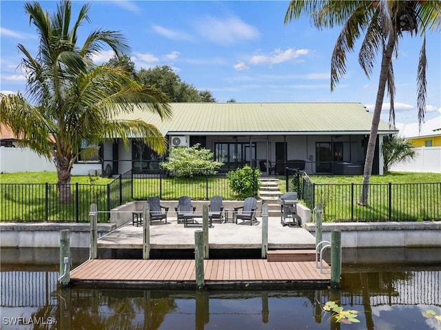 view of dock with a yard and a water view