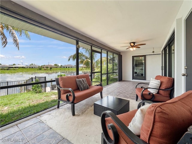 sunroom / solarium featuring ceiling fan and a water view