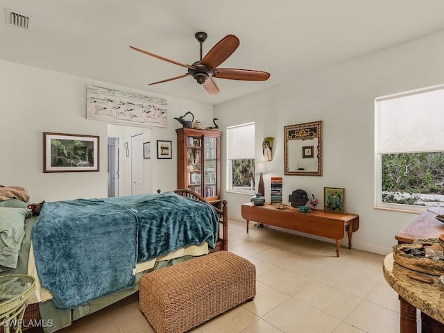 bedroom featuring ceiling fan, light tile patterned flooring, and multiple windows