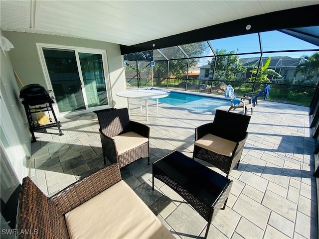 view of pool with glass enclosure and a patio area