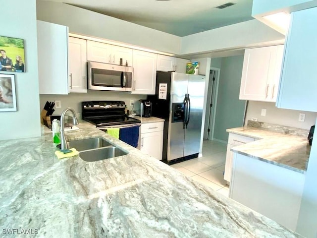 kitchen featuring light tile patterned flooring, sink, white cabinets, and stainless steel appliances