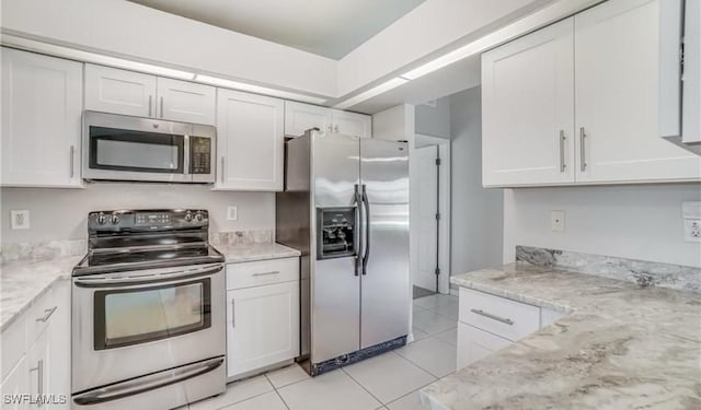 kitchen with light tile patterned flooring, light stone counters, white cabinetry, and stainless steel appliances