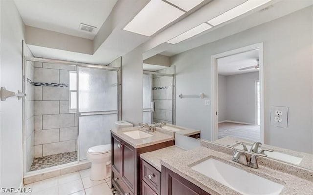 bathroom with tile patterned flooring, vanity, an enclosed shower, and toilet