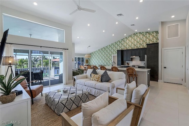 living room with ceiling fan, high vaulted ceiling, and light tile patterned floors