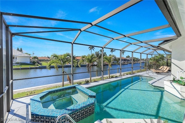 view of pool with an in ground hot tub, a patio, a water view, and glass enclosure