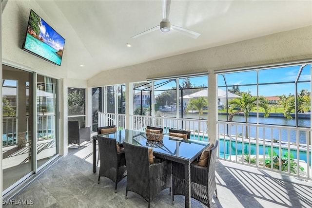 sunroom featuring ceiling fan, a water view, and lofted ceiling