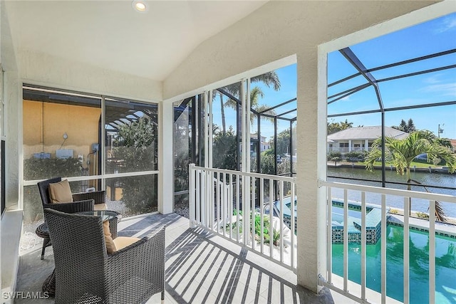 sunroom / solarium with a water view and vaulted ceiling