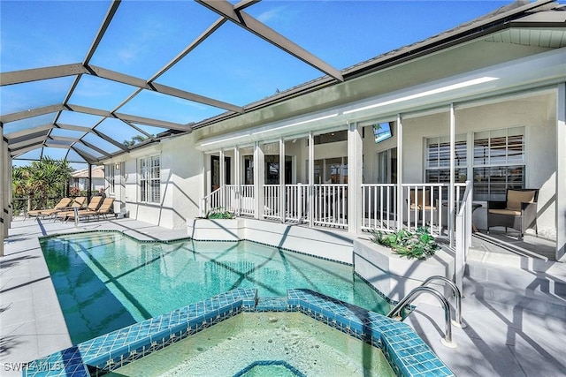 view of swimming pool featuring glass enclosure, an in ground hot tub, and a patio