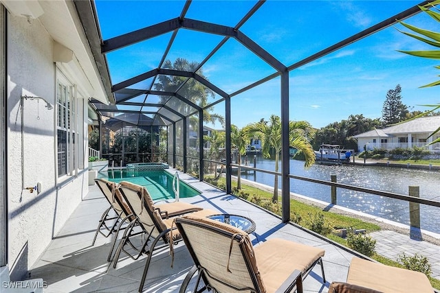 view of pool with a water view, glass enclosure, and a patio area