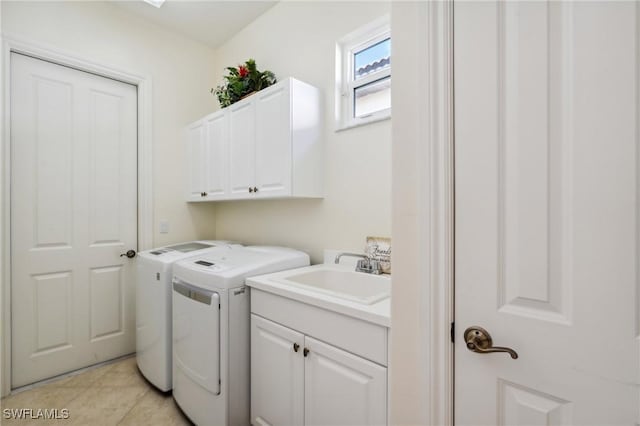 laundry room with washer and dryer, light tile patterned floors, cabinets, and sink