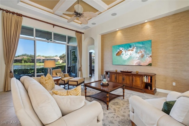 living room with coffered ceiling, ceiling fan, ornamental molding, light tile patterned floors, and beamed ceiling