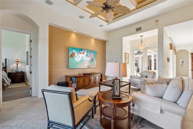 tiled living room featuring beamed ceiling, ornamental molding, ceiling fan, and coffered ceiling