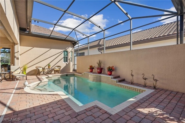 view of swimming pool with a patio and a lanai