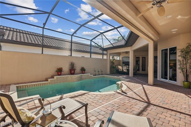 view of pool featuring glass enclosure, ceiling fan, french doors, and a patio area