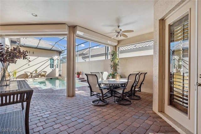 view of patio / terrace featuring glass enclosure and ceiling fan