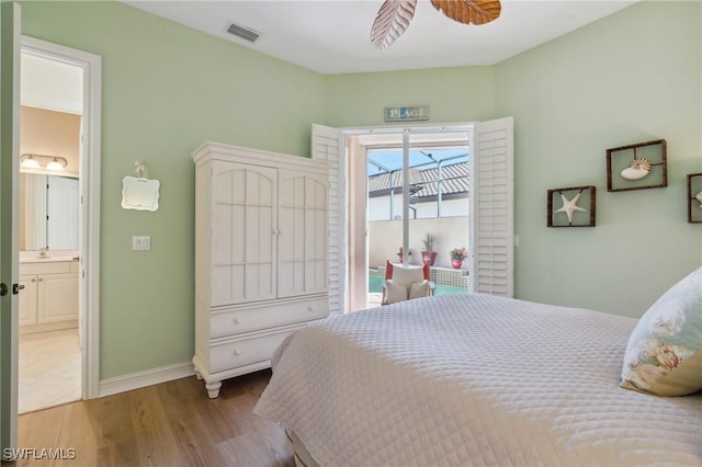 bedroom featuring ensuite bathroom, light hardwood / wood-style flooring, ceiling fan, and sink