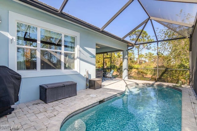 view of pool with a lanai, a patio area, and a grill