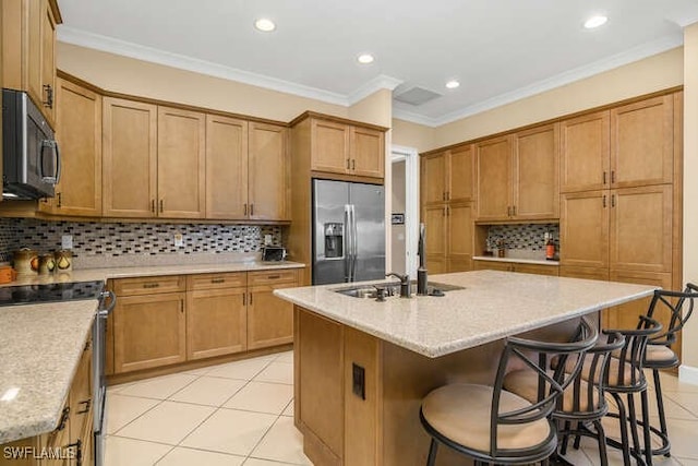 kitchen featuring backsplash, sink, stainless steel appliances, and a kitchen island with sink