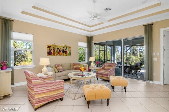 living room featuring ceiling fan, a raised ceiling, and light tile patterned floors