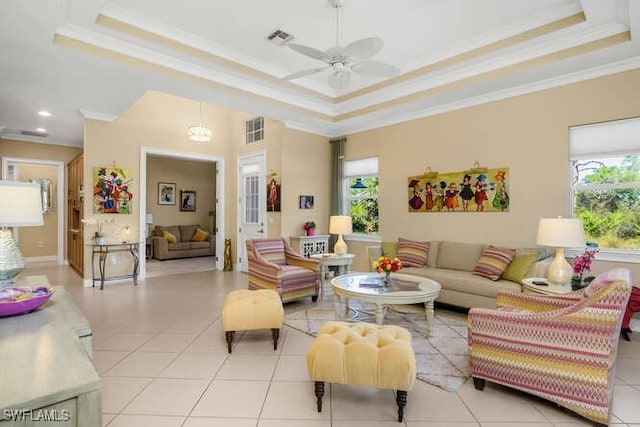 tiled living room with a raised ceiling, crown molding, and a healthy amount of sunlight