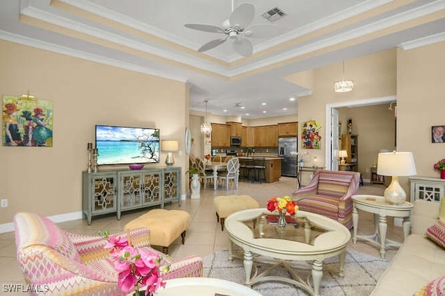 living room featuring ceiling fan, a raised ceiling, light tile patterned floors, and ornamental molding