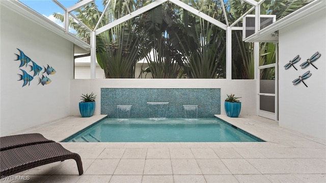 view of pool with pool water feature, a patio area, and a lanai