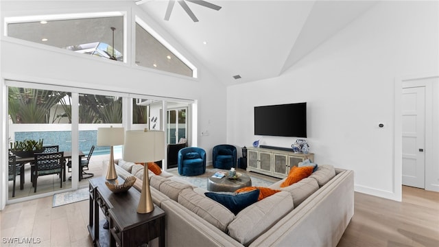 living room featuring ceiling fan, plenty of natural light, light hardwood / wood-style floors, and high vaulted ceiling