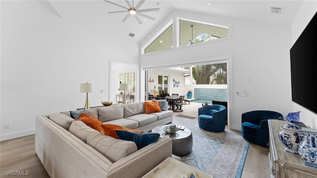 living room with ceiling fan, light hardwood / wood-style flooring, and high vaulted ceiling