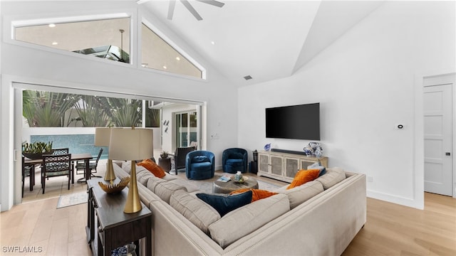 living room featuring ceiling fan, light hardwood / wood-style flooring, and high vaulted ceiling