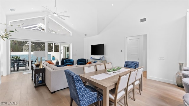 dining space featuring light hardwood / wood-style floors, high vaulted ceiling, and ceiling fan