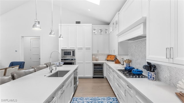 kitchen with beverage cooler, stainless steel appliances, premium range hood, decorative backsplash, and white cabinets